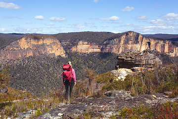 Image showing Female taking in magnificent vistas of sheer sandstone cliffs ac