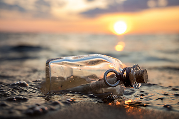 Image showing Message in the bottle against the Sun setting down