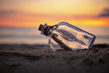 Image showing Message in the bottle against the Sun setting down