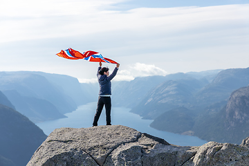 Image showing Woman with a waving flag of Norway on the background of nature