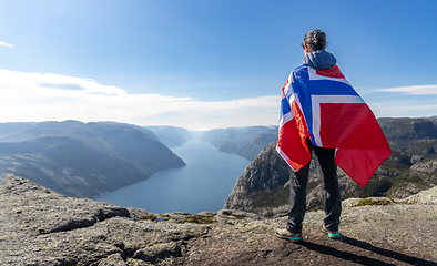 Image showing Woman with a waving flag of Norway on the background of nature