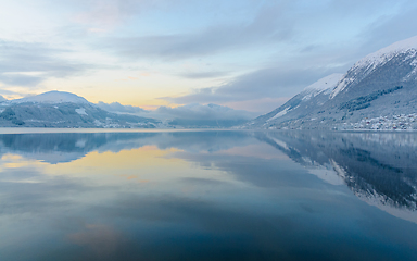 Image showing reflection in fjord with sun behind clouds