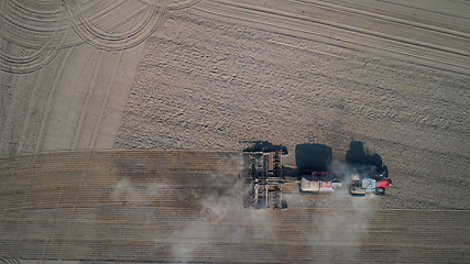 Image showing Farmer in tractor preparing land with seedbed cultivator, top view