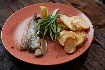 Image showing Pacific herring with fried potatoes and onion