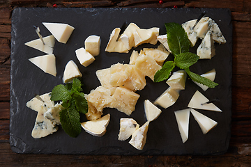 Image showing Cheeseboard Top View on Black Stone Plate Background