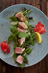 Image showing beautiful food: steak tuna in sesame, lime and fresh salad close-up on a plate on the table.