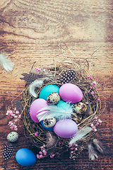 Image showing Happy Easter - nest with Easter eggs on wooden background with copy space