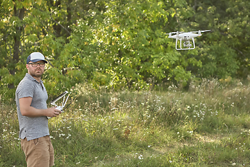 Image showing Man manages quadrocopters. Remote control for the drone in the hands of men. Unmanned aerial vehicle