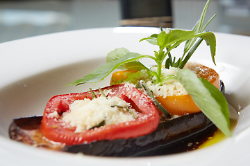 Image showing Baked eggplant with parmesan cheese, tomatoes and basil.