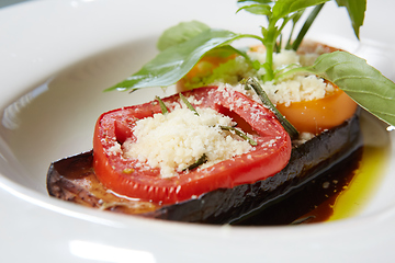 Image showing Baked eggplant with parmesan cheese, tomatoes and basil.