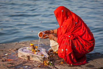 Image showing Indian woman performs morning pooja on holy river Narmada ghats