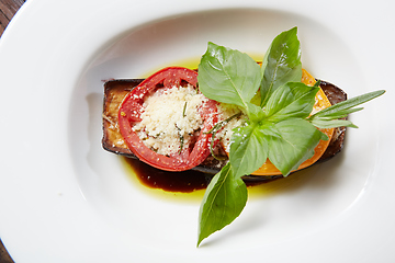 Image showing Baked eggplant with parmesan cheese, tomatoes and basil.