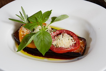Image showing Baked eggplant with parmesan cheese, tomatoes and basil.