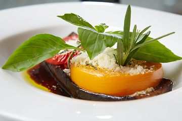 Image showing Baked eggplant with parmesan cheese, tomatoes and basil.