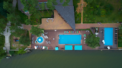 Image showing Aerial view of luxury house garden with swimming pool surrounded by trees.