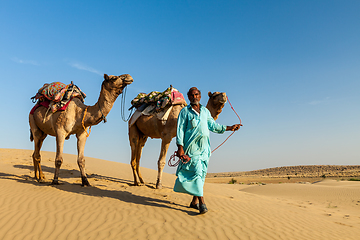 Image showing Cameleer (camel driver) with camels in dunes of Thar desert. Raj