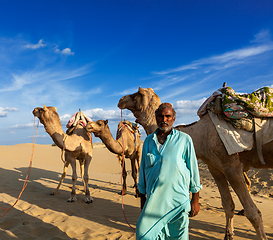 Image showing Cameleer (camel driver) with camels in dunes of Thar desert. Raj