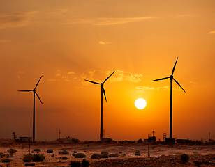 Image showing Wind generator turbines sihouettes on sunset