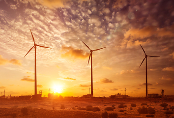 Image showing Wind generator turbines sihouettes on sunset