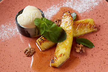 Image showing Grilled pineapple with scoops of vanilla ice cream.