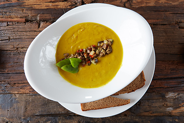 Image showing Healthy vegetable cream soup with herbs. Top view.