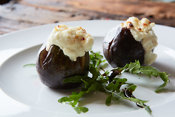 Image showing baked figs with goat cheese on wooden table