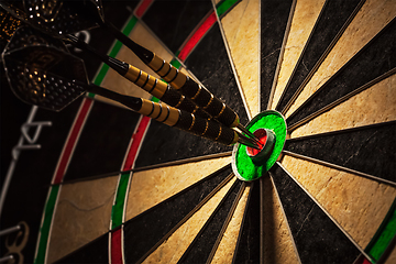 Image showing Three darts in bull's eye close up