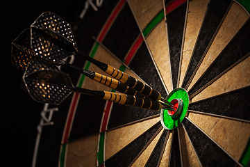 Image showing Three darts in bull's eye close up