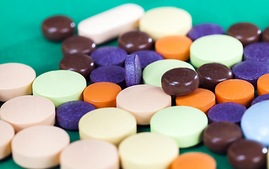 Image showing Multi-colored pills on a green background