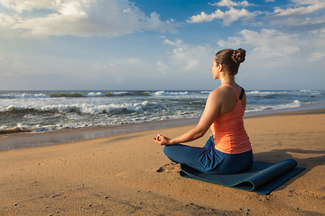 Image showing Woman doing yoga Lotus pose oudoors at beach