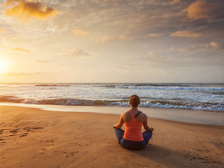 Image showing Young sporty fit woman doing yoga oudoors at beach