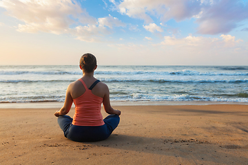 Image showing Young sporty fit woman doing yoga oudoors at beach