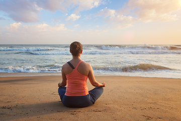 Image showing Woman doing yoga Lotus pose oudoors at beach