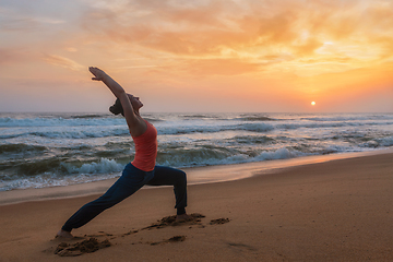 Image showing Woman doing yoga asana Virabhadrasana 1 Warrior Pose on beach on