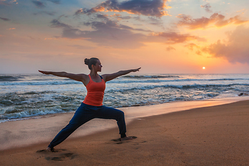 Image showing Woman doing yoga asana Virabhadrasana 1 Warrior Pose on beach on