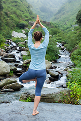 Image showing Woman in yoga asana Vrikshasana tree pose at waterfall outdoors