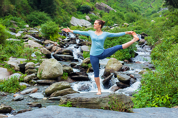 Image showing Woman doing Ashtanga Vinyasa Yoga asana outdoors at waterfall