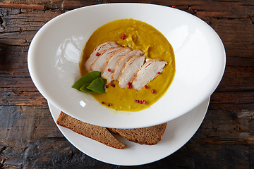 Image showing Pumpkin and carrot soup with chicken. Top view. Copy space.