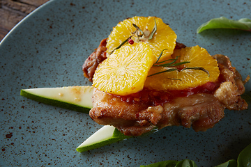 Image showing Chicken Steak with oranges and greens. Shallow dof.