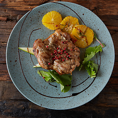 Image showing Chicken Steak with oranges and greens. Shallow dof.