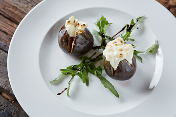 Image showing baked figs with goat cheese on wooden table