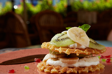 Image showing Fresh waffles with ice cream and maple syrup.