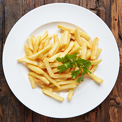 Image showing French fries in a bowl on a wooden background.