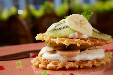 Image showing Fresh waffles with ice cream and maple syrup.