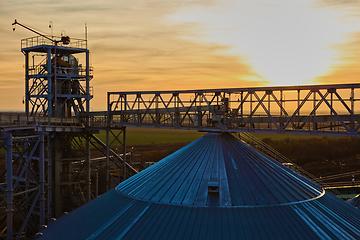 Image showing grain silo and dryer at night with pile of grain.