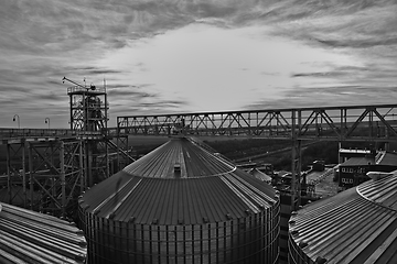 Image showing grain silo and dryer at night with pile of grain.