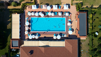 Image showing Aerial view on people in swimming pool. Top view of people sunbathing pool.