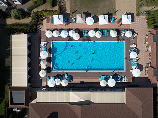 Image showing Aerial view on people in swimming pool. Top view of people sunbathing pool.