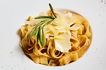 Image showing Close-up italian pasta plate with grated parmesan cheese and basil leaf