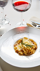 Image showing Close-up italian pasta plate with grated parmesan cheese and basil leaf